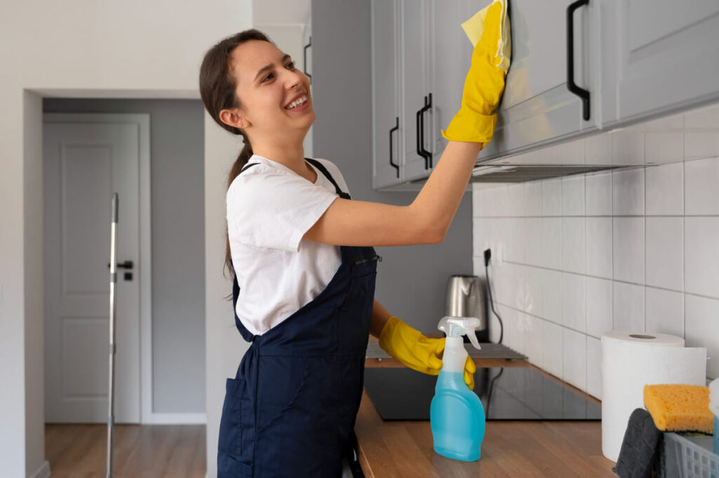 Putzfrau reinigt eine Küche und hat Spaß an ihrer Arbeit